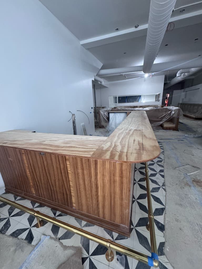BESOS bar under construction with wood veneer and geometric tile floor