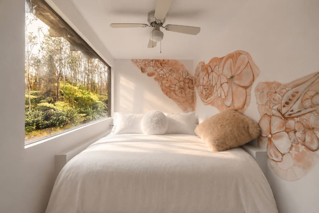Bedroom with hand-painted mural and rainforest view