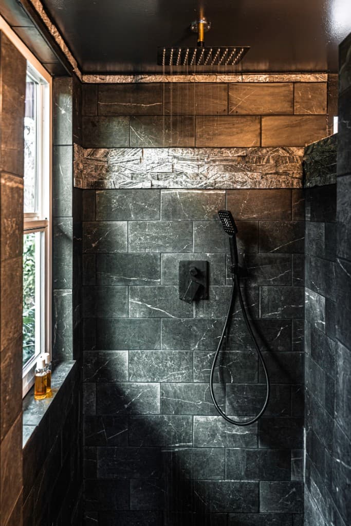 Walk-in shower with dark marble tile